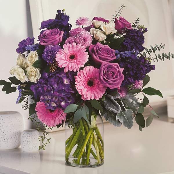 Bouquet of pink and purple flowers in a clear glass vase