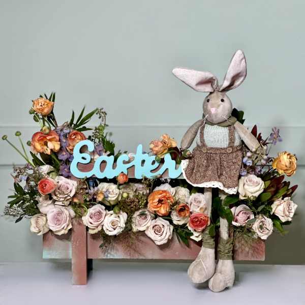 Easter floral arrangement with roses and a plush bunny