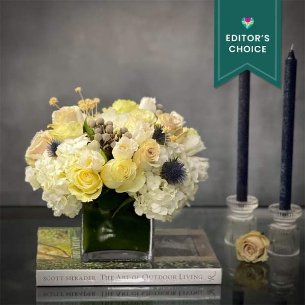 Cream and pale yellow bouquet in a square glass vase