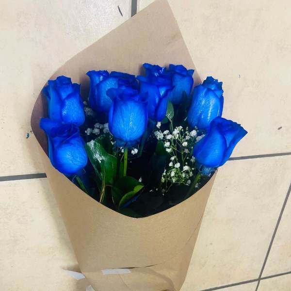 Bouquet of blue roses wrapped in brown paper with a white ribbon