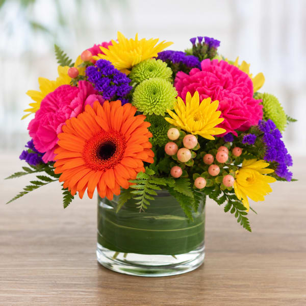 Bright mixed bouquet in a glass vase with gerbera daisies and chrysanthemums