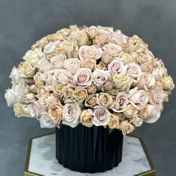 Large bouquet of pale pink and cream roses in a dark vase