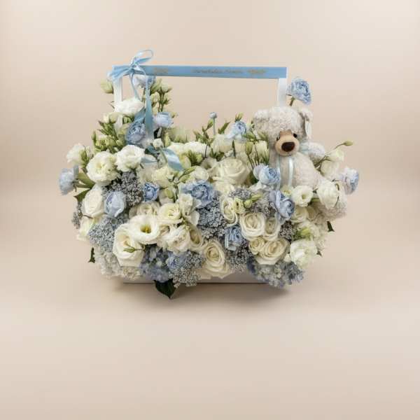White and pale blue floral basket with a teddy bear
