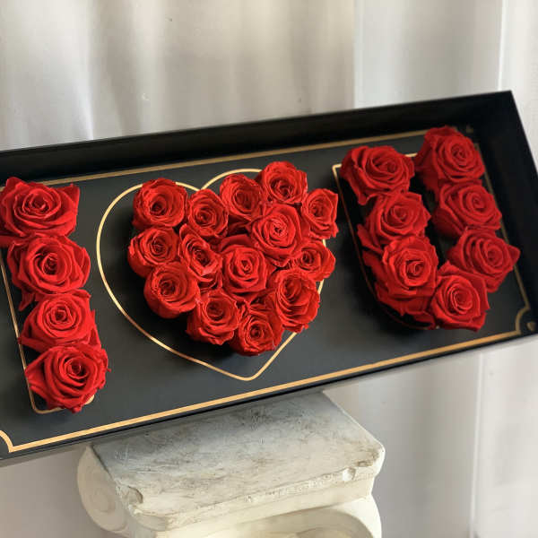 Red roses arranged as the word "I" and a heart in a black box