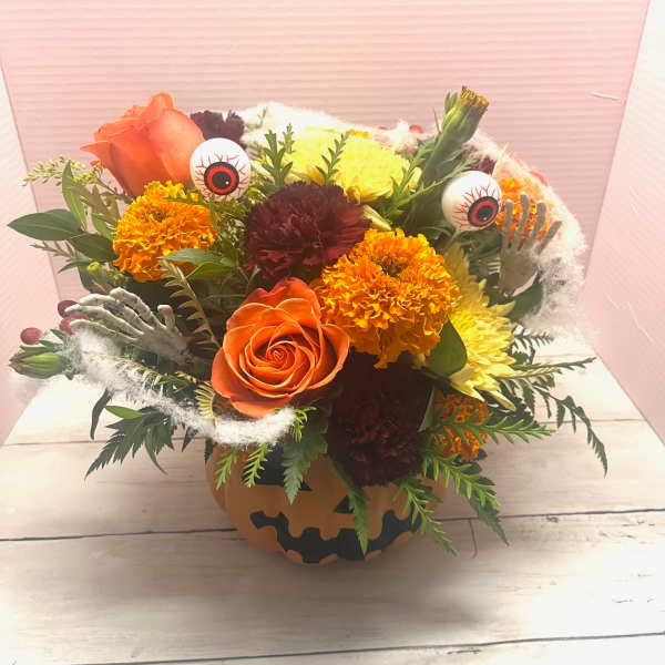 Halloween bouquet in a pumpkin container with roses, marigolds, and eyeball picks
