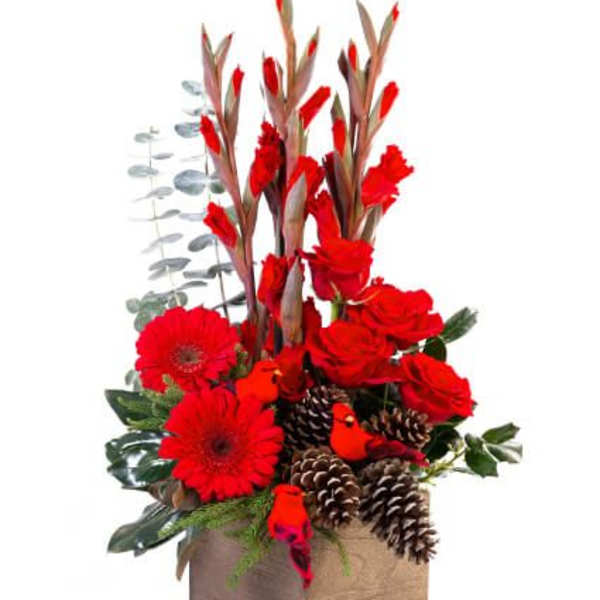 Red flowers and pinecones in a square box arrangement