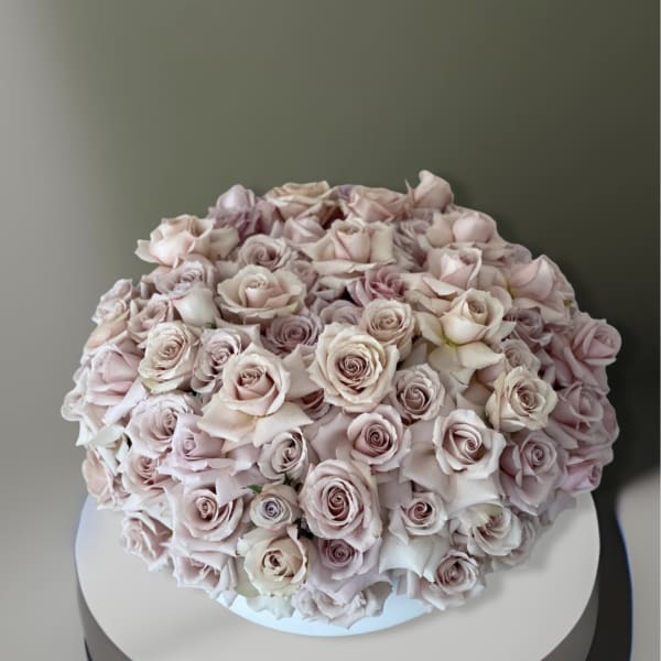 Large bouquet of pale pink roses in a white container