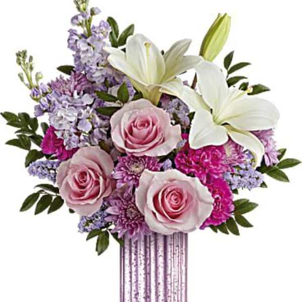 Tall pink ribbed vase with white lilies, pink roses, and lavender mixed flowers