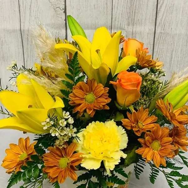 Yellow lilies and orange daisies in a mixed bouquet