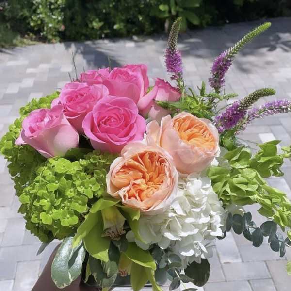Bouquet of pink and peach roses with white hydrangea and purple spikes
