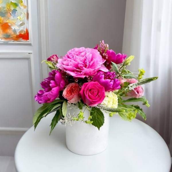 Pink and magenta flower arrangement in a white vase