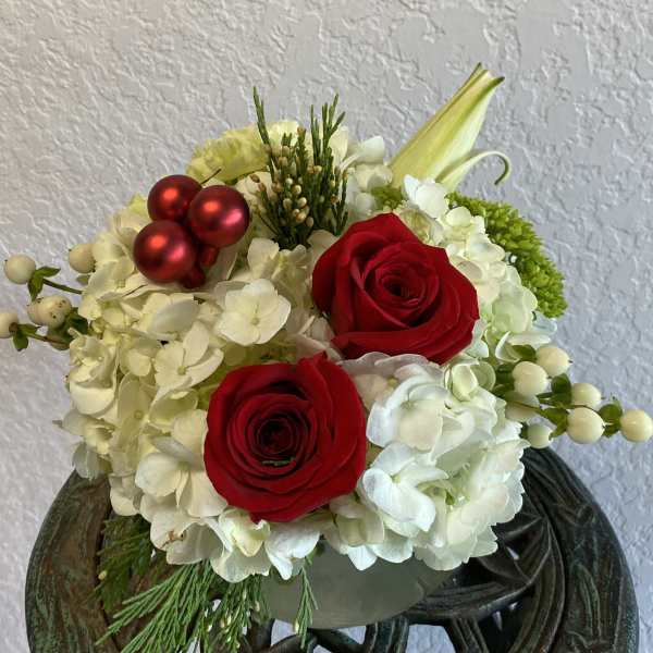 Red roses and white hydrangeas in a low arrangement with red ornaments