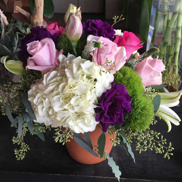 Bouquet of pink, purple, and white flowers in a terracotta pot
