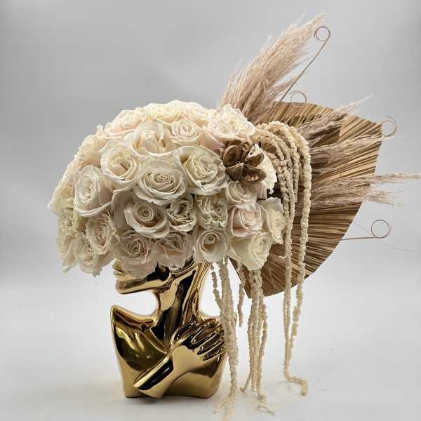 Cream rose bouquet in a gold sculptural vase with dried pampas accents