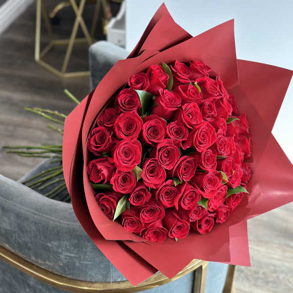 Bouquet of red roses wrapped in red paper