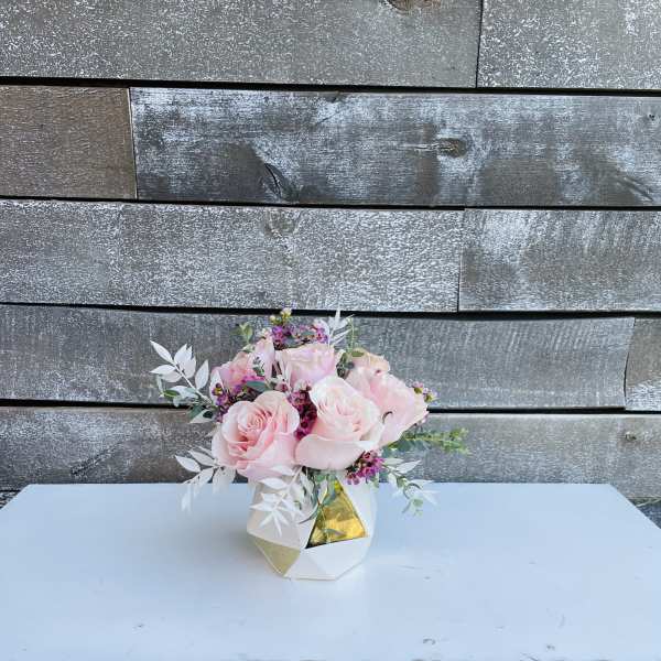 Pink roses arranged in a small geometric vase
