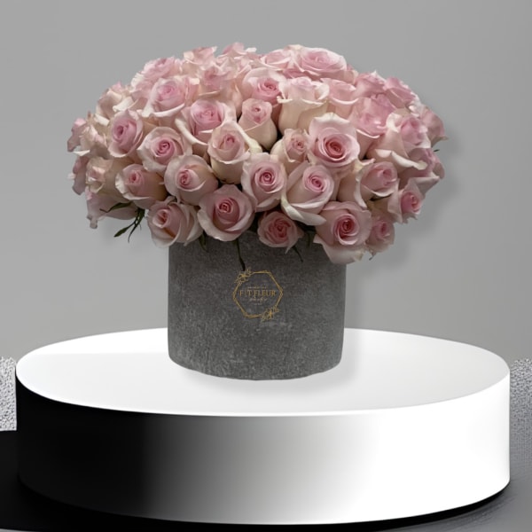 Bouquet of pale pink roses in a gray hatbox