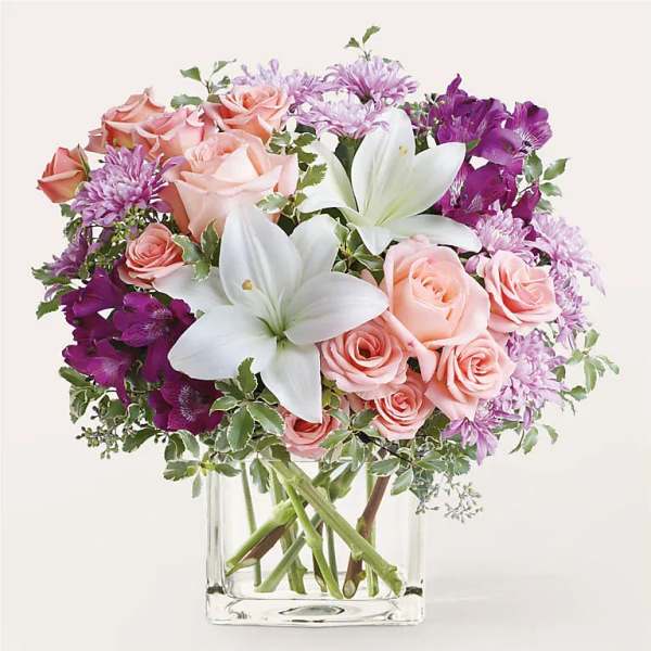 Pink roses and white lilies in a clear glass vase