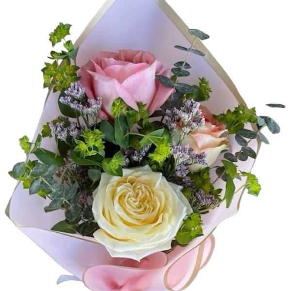 Bouquet of pink and cream roses wrapped in pastel paper