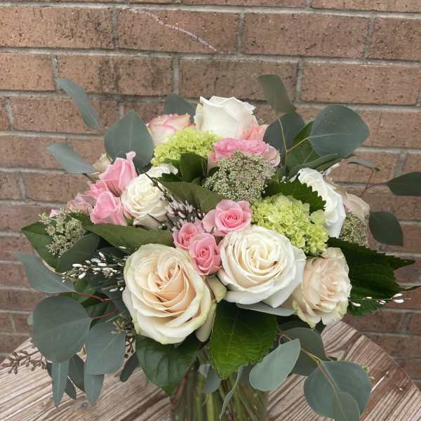 Bouquet of pink and white roses in a glass vase