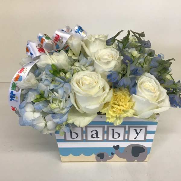 White roses and blue flowers in a baby-themed box