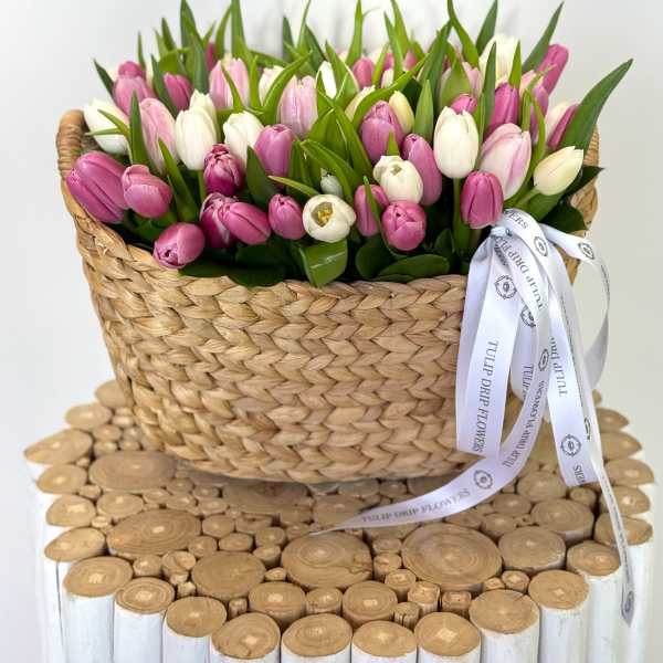 Basket of pink and white tulips with a ribbon