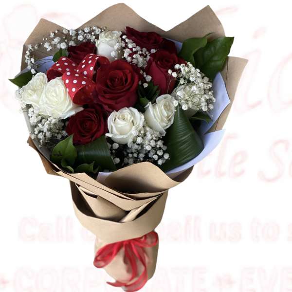 Bouquet of red and white roses wrapped in brown paper with a red ribbon