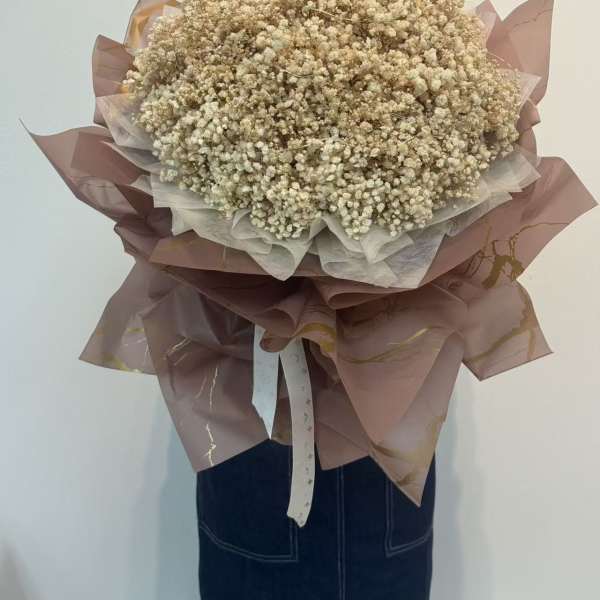 Large bouquet of cream baby's breath wrapped in mauve paper