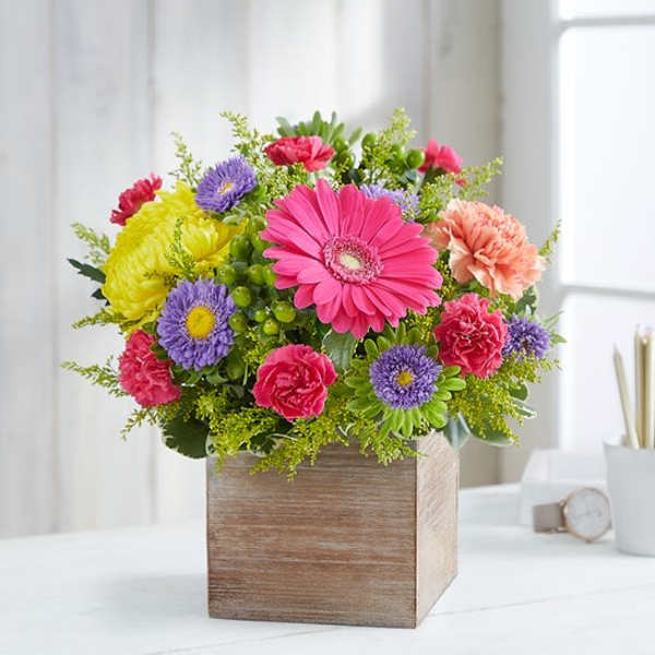 Colorful mixed bouquet in a wooden cube vase