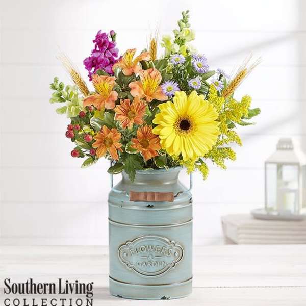 Mixed bouquet in a blue metal milk can vase