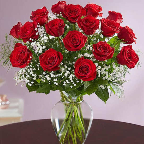 Bouquet of red roses with baby's breath in a clear glass vase