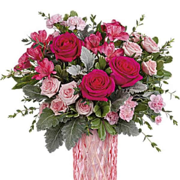 Pink and magenta rose bouquet in a pink glass vase