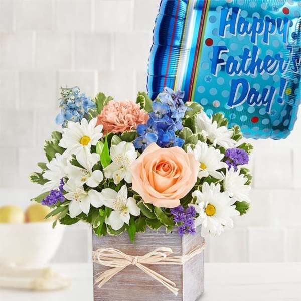 Mixed flower arrangement in a wooden box with a Father's Day balloon