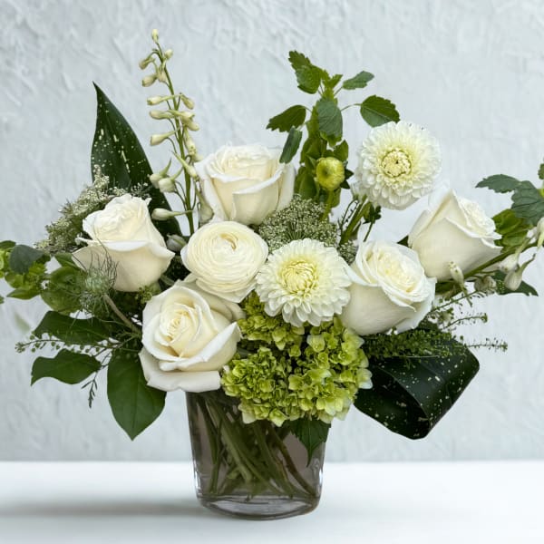 White roses and mixed white blooms in a glass vase