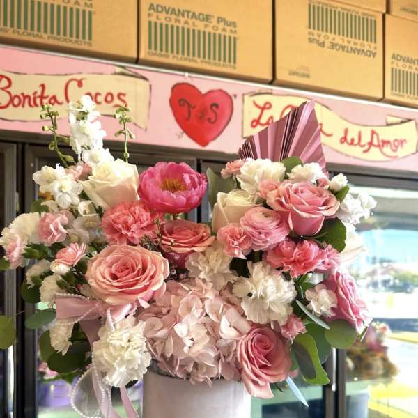 Pink and white floral arrangement in a white hat box
