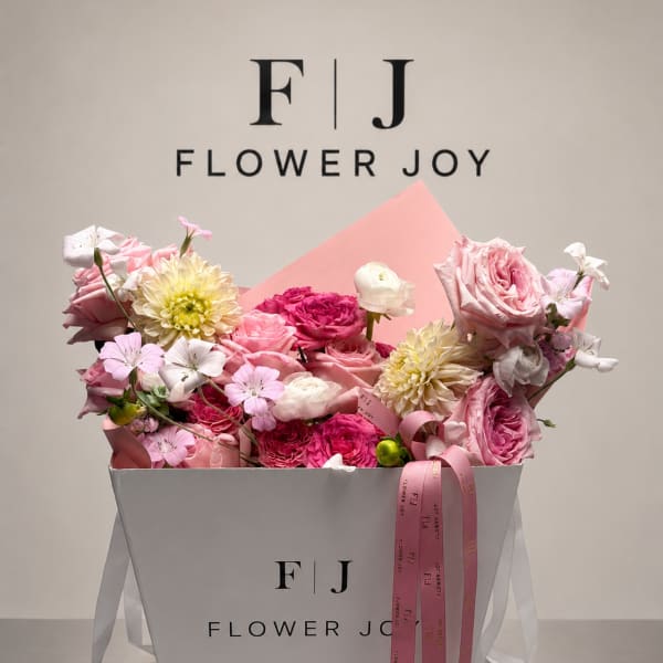 Pink and white flower bouquet in a white gift box with ribbon