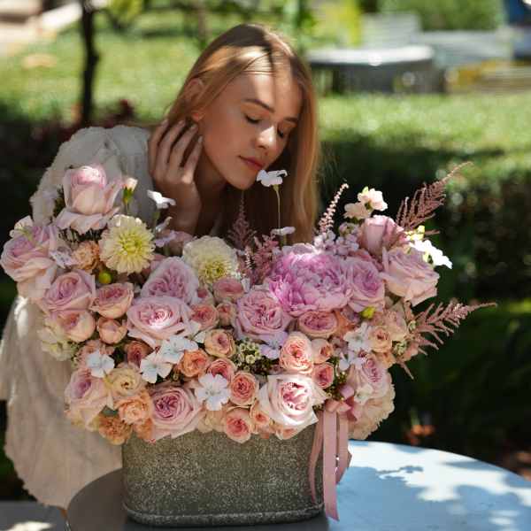 Large pink and cream rose arrangement in a gray container