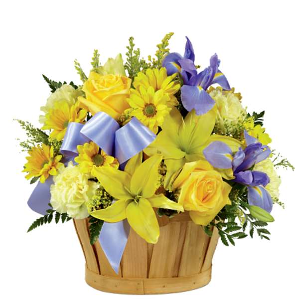 Yellow and purple flower arrangement in a wooden basket with ribbon