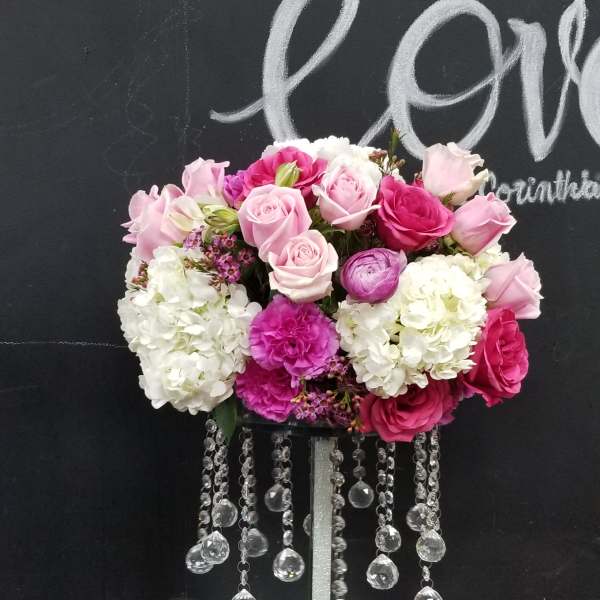 Pink and white rose arrangement on a tall stand with crystal strands