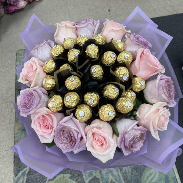 Bouquet of pink and lavender roses with gold-wrapped chocolates