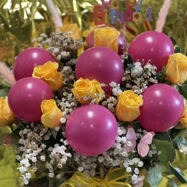 Basket arrangement with yellow roses and pink balloons