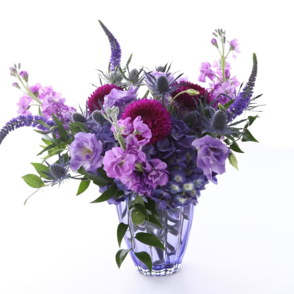 Purple and pink flowers arranged in a clear glass vase