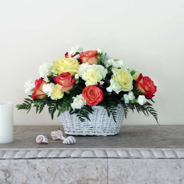 Basket of red, yellow, and white roses with carnations