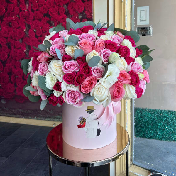 Large pink and white rose arrangement in a round hat box