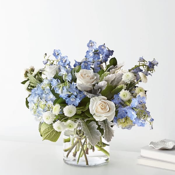 Blue and white flower arrangement in a clear glass vase