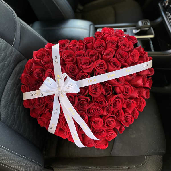 Heart-shaped bouquet of red roses with a white Dior ribbon