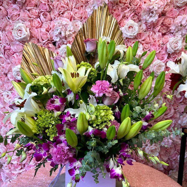 Large bouquet of lilies, orchids, and pink flowers in a box