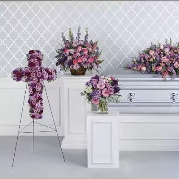 Purple and pink floral funeral casket spray with matching standing arrangements