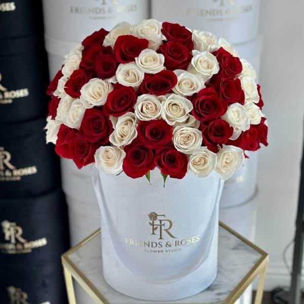 Red and white roses arranged in a white hat box