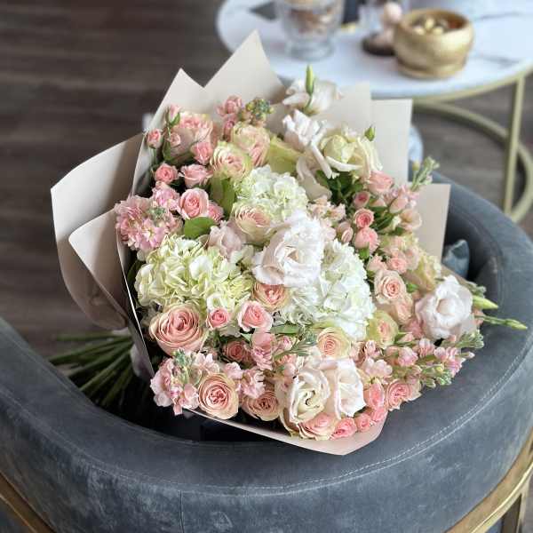 Bouquet of pink and white roses with pale hydrangeas in paper wrap